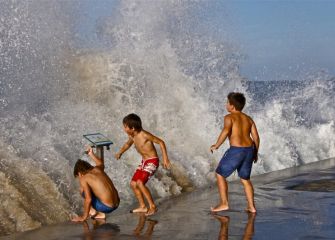 Niños jugando con las olas 