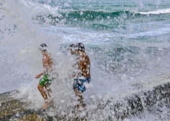 Niños jugando con las olas 