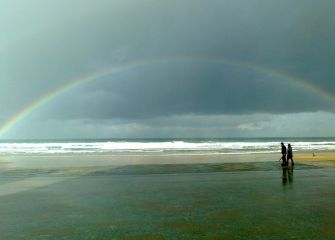 PAREJA PASEANDO BAJO EL ARCO IRIS