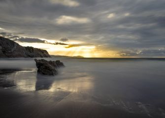 Atardecer con nubes y rayos de sol.