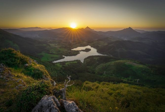 rayos dorados sobre cumbres y pantano: foto en Oñati